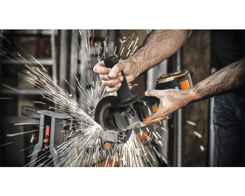 Un homme meule du métal avec une meuleuse d''angle sans fil, des étincelles jaillissent