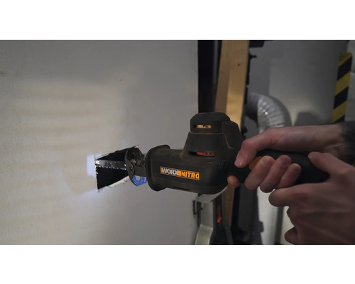 Une personne scie un trou dans un mur avec une scie sabre. Outil de Worx Nitro.