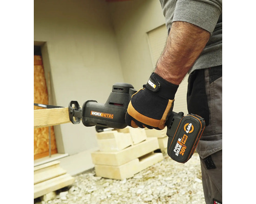 Une personne utilise une scie sabre sans fil Worx Nitro pour couper une planche de bois.