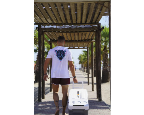 Homme avec glacière à la plage