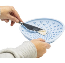 Person drückt mit einem Messer eine Creme durch ein Silikonsieb
