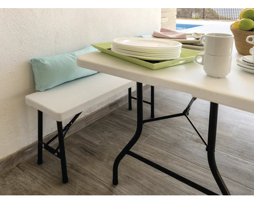 Szene mit Gartentisch, Gartenbank und Geschirr auf einer Terrasse