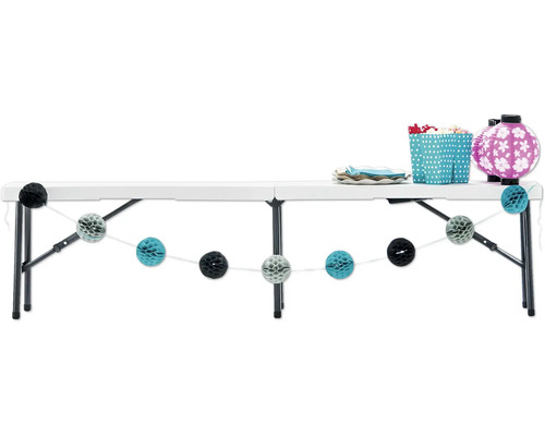 Dekorierter, weißer Klapptisch mit Geschirr, Laternen und Girlanden