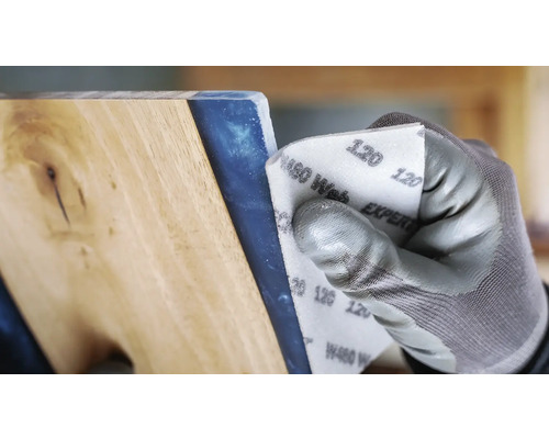 Eine Person schleift ein Werkstück mit Schleifpapier der Körnung 120.