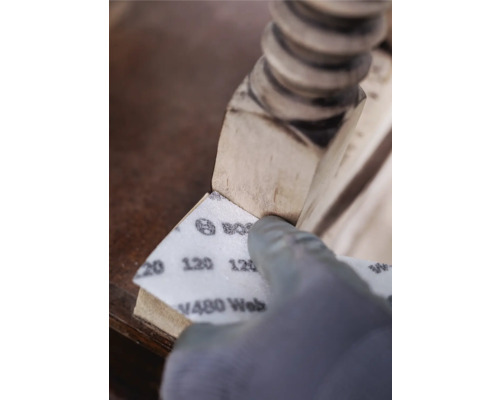 Schleifen eines Holzbeins mit Schleifpapier der Körnung 120