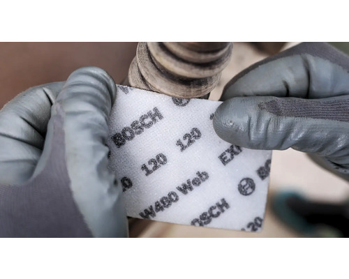 Eine Person schleift mit einem Bosch Schleifvlies der Körnung 120 ein Werkstück.