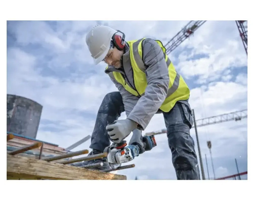 Bauarbeiter schneidet mit einem Winkelschleifer Bewehrungsstahl auf einer Baustelle.