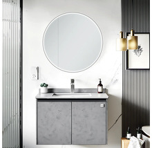 Modernes Badezimmer mit Waschtisch, rundem Spiegel mit Beleuchtung und dekorativen Elementen.
