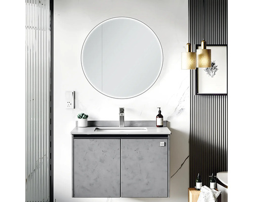 Salle de bain moderne avec meuble-lavabo, miroir rond avec éclairage et éléments décoratifs.