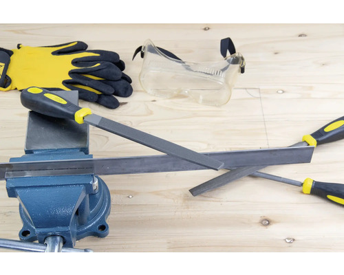 Établi avec étau, limes à métaux, lunettes de protection et gants de travail