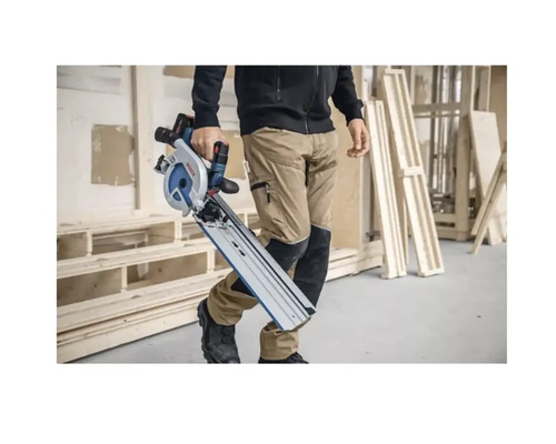 Une personne porte une scie plongeante Bosch avec un rail de guidage.