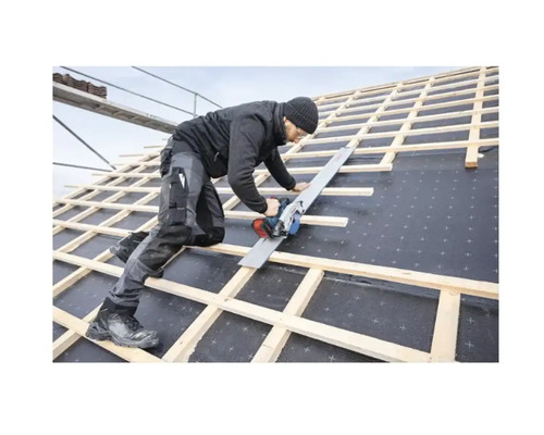 Un artisan scie avec une scie circulaire à main sur un toit.