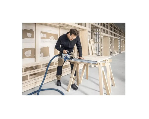 Artisan coupant une plaque de bois avec une scie circulaire sur un établi