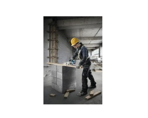 Un artisan avec un casque de protection est en train de scier une planche de bois avec une scie circulaire.