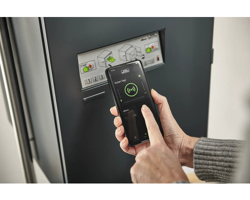 Eine Person bedient eine Paketbox mit einer Smartphone-App.
