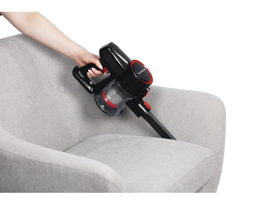 Akkusauger bei der Reinigung eines Sessels.