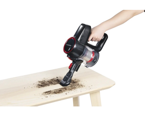 Akkusauger in Verwendung auf einem Holztisch zur Reinigung von Schmutz