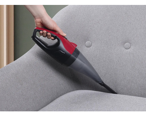 Handstaubsauger bei der Reinigung eines grauen Stoffsofas