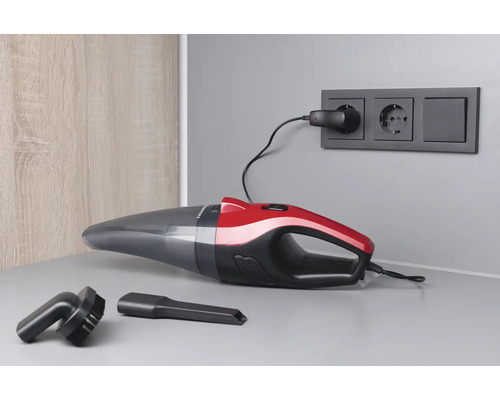 Akkusauger mit Düsen und Ladegerät an Steckdose