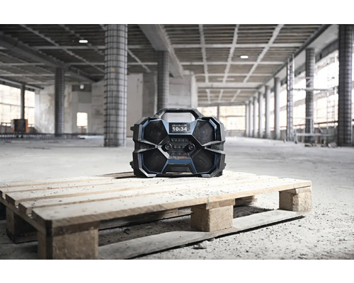 Baustellenradio auf Holzpalette vor einem Rohbau