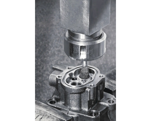 Brosse métallique nettoyant une pièce métallique