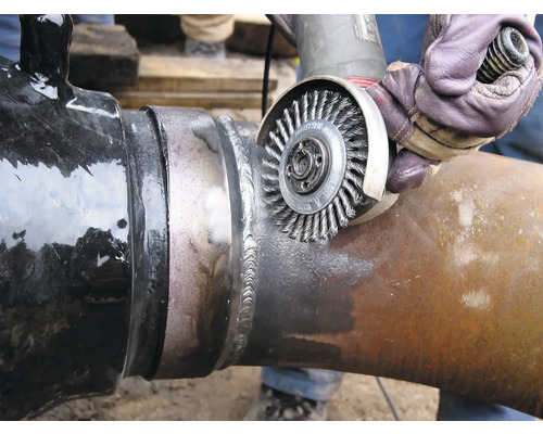 Nettoyage de tuyau avec une brosse métallique sur une soudure