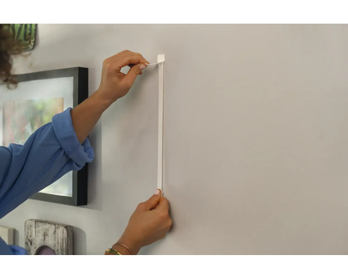 Personne fixant une cimaise au mur