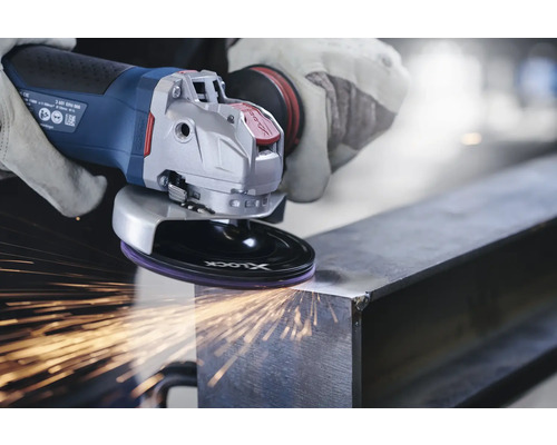 Eine Person schleift mit einem Akku-Winkelschleifer ein Metallstück, wobei Funken entstehen.