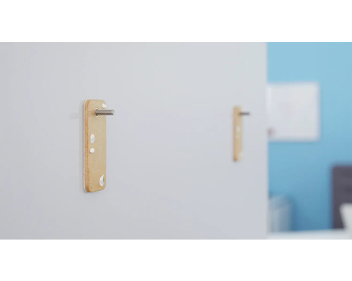 Deux connecteurs de meubles fixés à un mur avec des vis