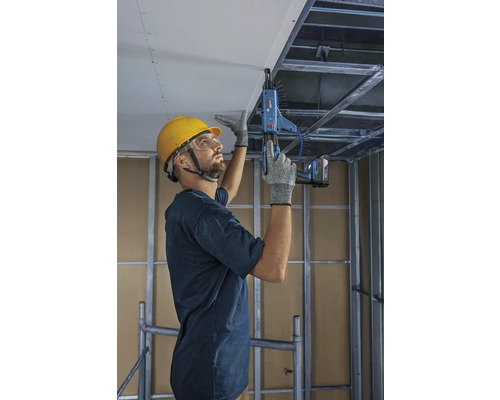 Artisan fixant des plaques de plafond avec un tournevis à magasin