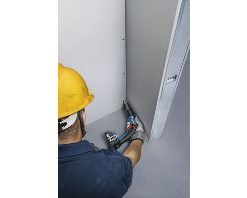 Artisan avec une perceuse-visseuse sans fil effectuant des travaux de construction sèche