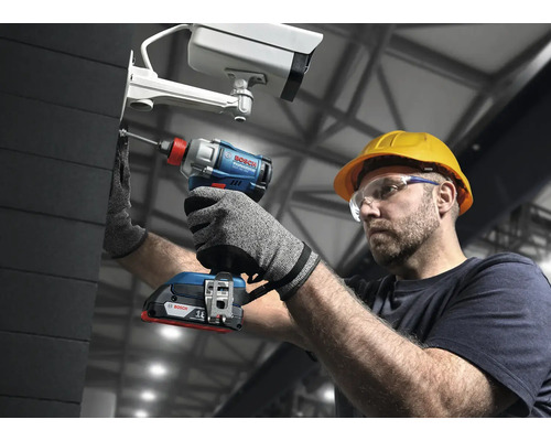 Ein Mann mit Schutzbrille und Schutzhelm befestigt eine Überwachungskamera mit einem Akku-Schlagschrauber von Bosch.