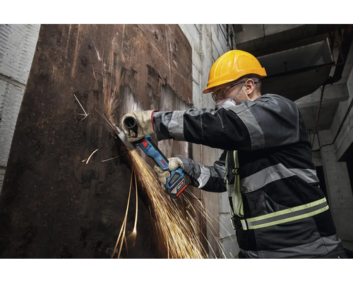 Ouvrier coupant du métal avec une meuleuse d'angle sans fil