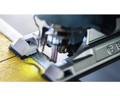 Gros plan d''une scie sauteuse coupant du bois avec le logo Bosch