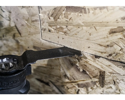 Outil oscillant sciant une plaque de bois