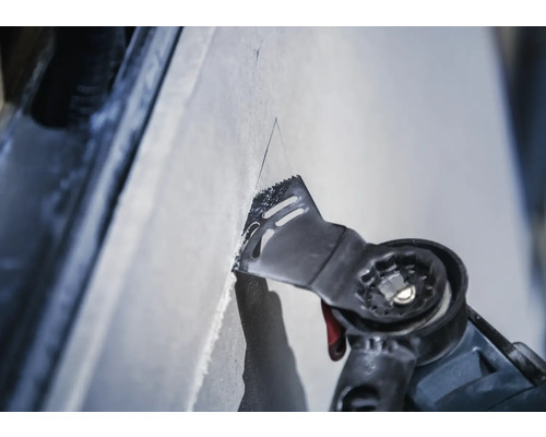 Outil électrique oscillant coupant dans une surface.