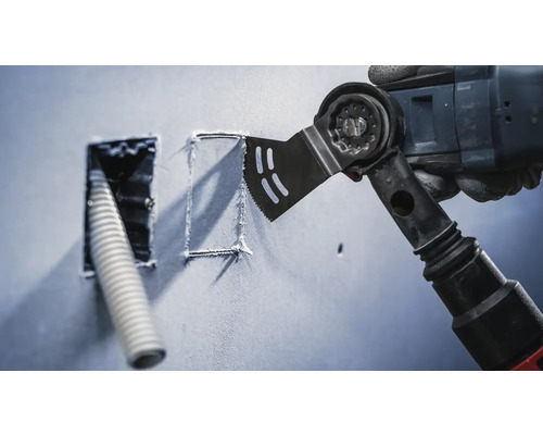 Outil électrique oscillant découpant une forme carrée dans un mur à côté d''une ouverture avec un câble