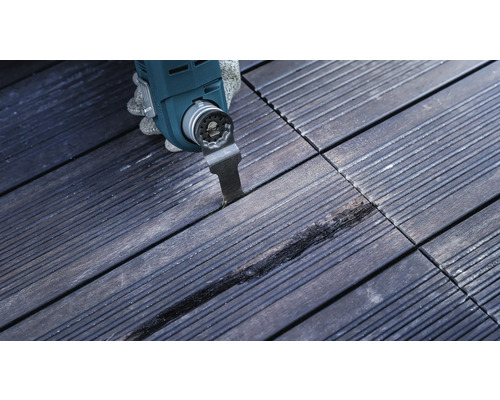 Outil multifonction en cours d''utilisation sur une terrasse en bois