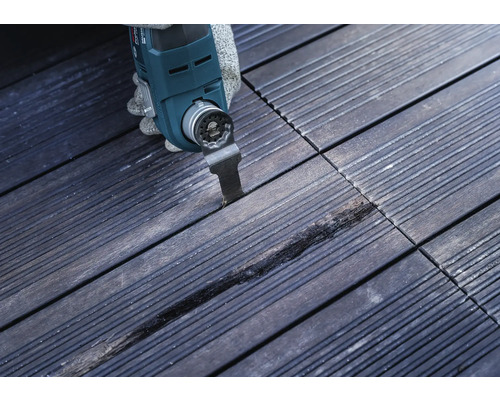 Outil multifonction en cours d''utilisation sur des carreaux de bois