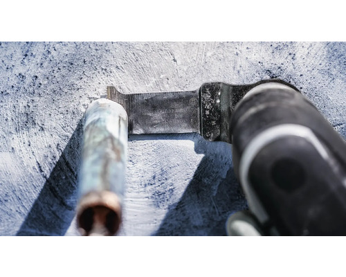 Outil multifonction avec lame de scie à métaux coupant un tuyau métallique