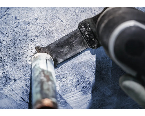 Outil électrique oscillant avec lame de scie en cours d''utilisation pour couper un tuyau.