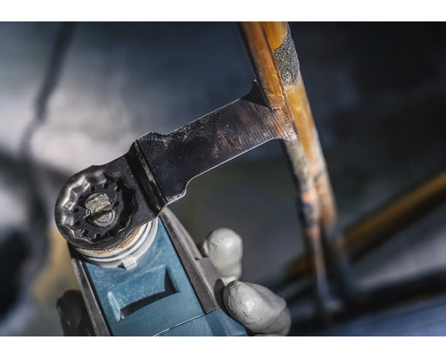 Une machine multifonction oscillante coupe un tuyau de cuivre.