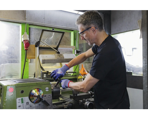 Un homme travaille sur un tour dans un atelier.