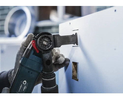 Outil multifonction en cours d''utilisation pour scier une plaque