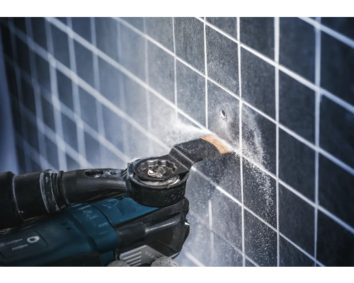 Outil multifonction en utilisation sur des carreaux