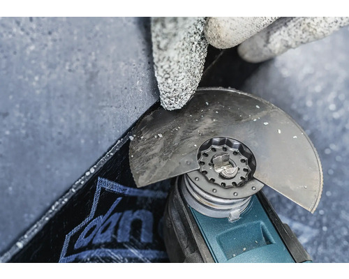 Nahaufnahme einer Person mit Schutzhandschuhen, die mit einem Winkelschleifer eine Platte bearbeitet.