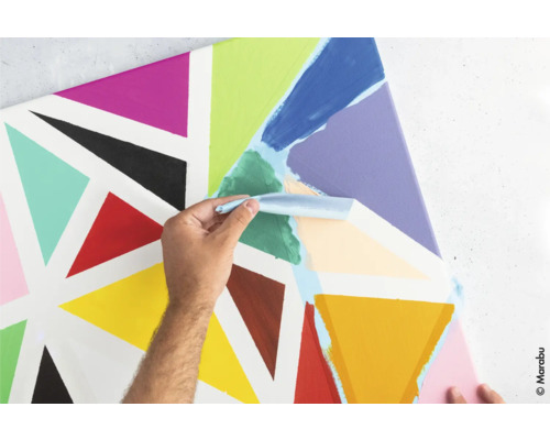 Person trägt Farbe mit Spachtel auf Leinwand mit Dreiecken auf