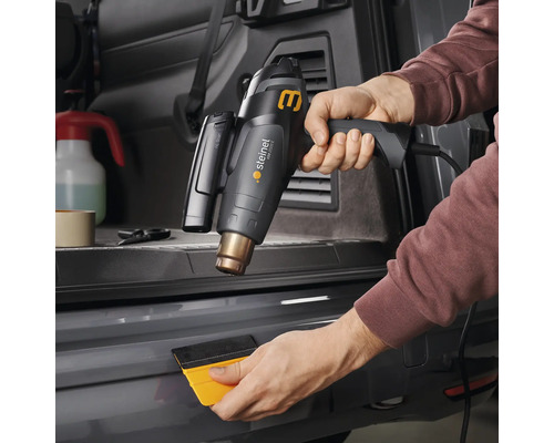 Heißluftpistole beim Folieren eines Stoßfängers