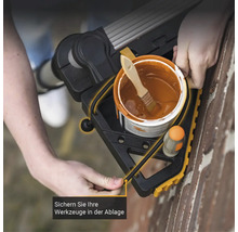 Farbeimer und Pinsel auf der Werkzeugablage einer Leiter