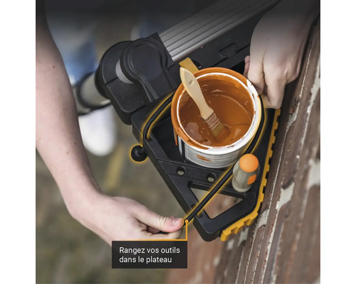 Pot de peinture et pinceau sur une plateforme de travail